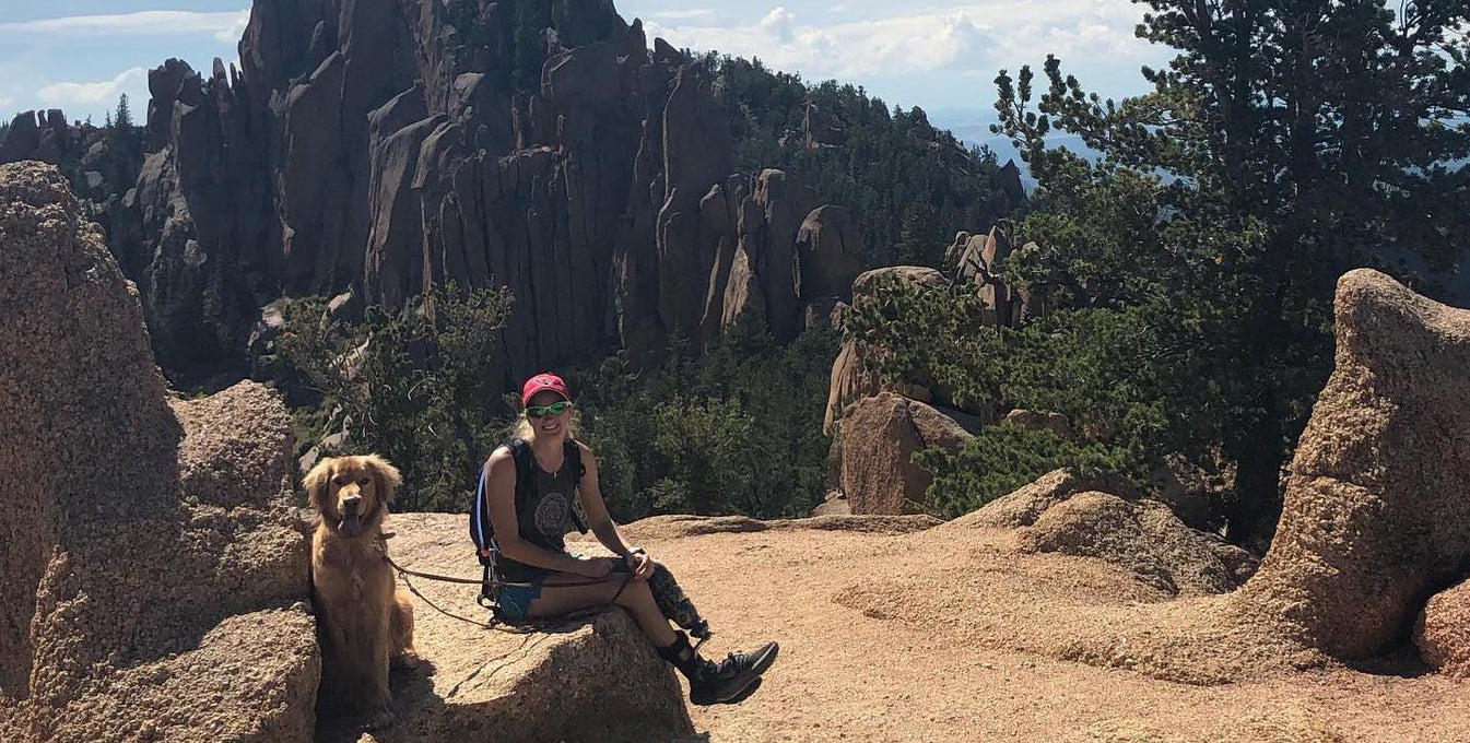 Allysa Seely sits with her service dog on a hike. 