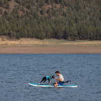 Brad and umi sitting on a paddleboard in a lake