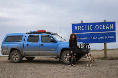 Raya and Grimlock pose by their van at the Arctic Ocean sign.